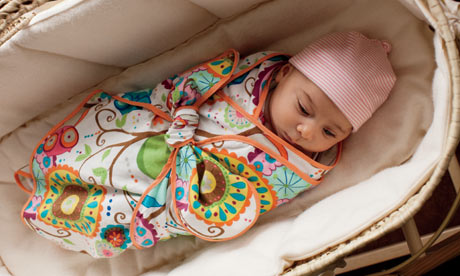 A baby in a swaddle blanket