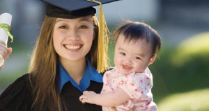 Young woman graduate holding baby