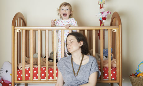 The author, with closed eyes, and cheering baby in cot