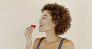 Young woman eating an organic strawberry