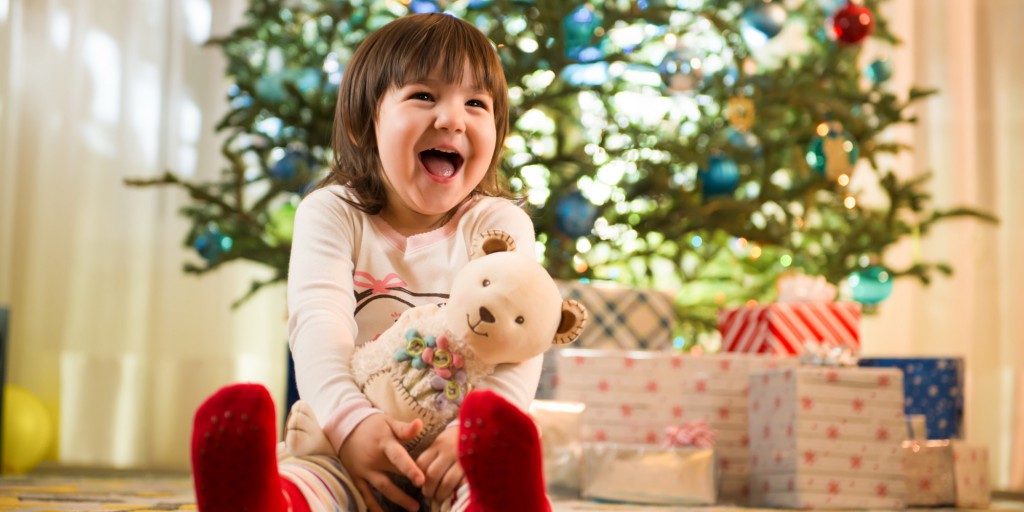 Girl laughing by Christmas tree