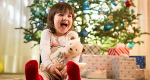 Girl laughing by Christmas tree