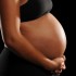 Young African American Woman Pregnant isolated on a black background