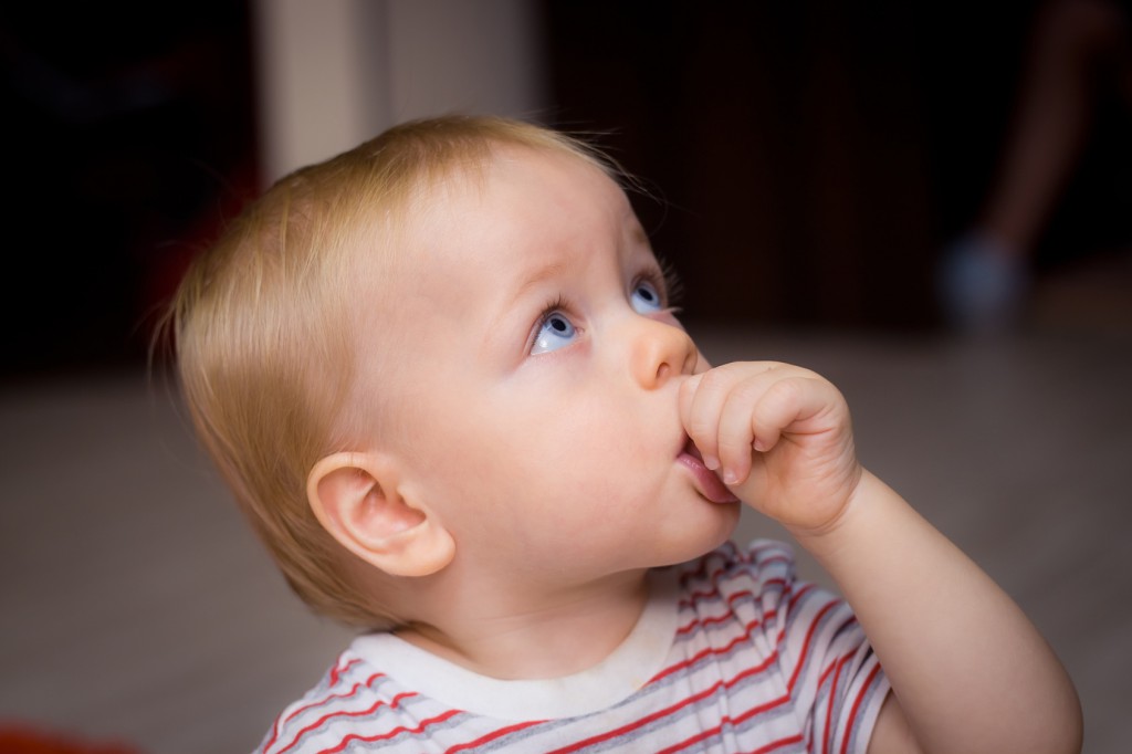 Baby boy sucking his thumb at home