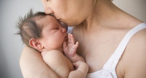 Mother kissing newborn